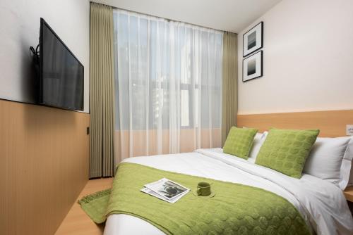 a bedroom with a bed with a flat screen tv at SHI MO LI Hotel 诗茉莉酒店 in Shenzhen