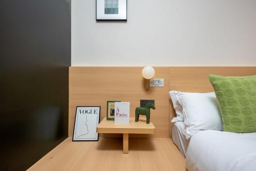a bedroom with a bed and a table with a book at SHI MO LI Hotel 诗茉莉酒店 in Shenzhen