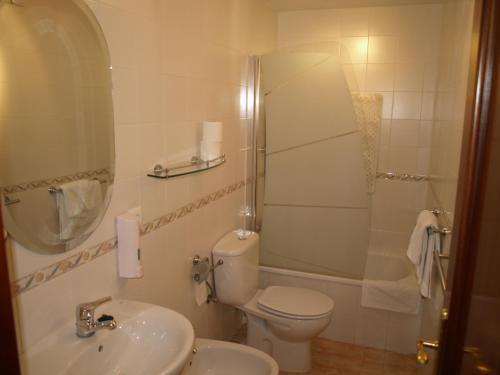 y baño con aseo, lavabo y ducha. en Hotel San Jorge, en Alcalá de los Gazules