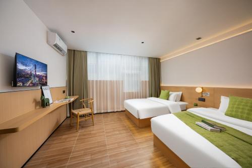 a hotel room with two beds and a desk at SHI MO LI Hotel 诗茉莉酒店 in Shenzhen