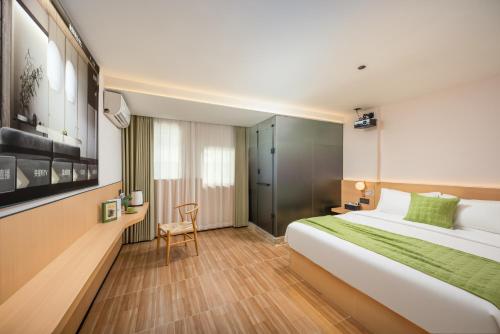 a hotel room with a large bed and a chair at SHI MO LI Hotel 诗茉莉酒店 in Shenzhen