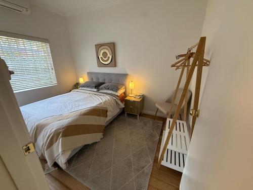 a small bedroom with a bed and a window at Stylish Comfort on the Park in Melbourne