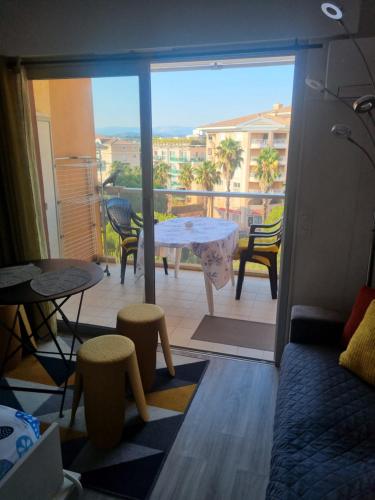 une chambre avec un balcon avec une table et des chaises dans l'établissement le capitole, à Fréjus
