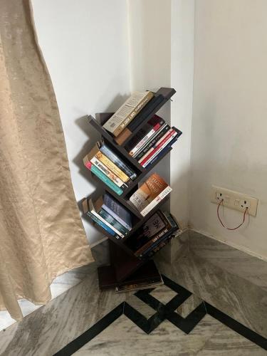 a book shelf filled with books next to a wall at Gayatri Guest House in Sukna