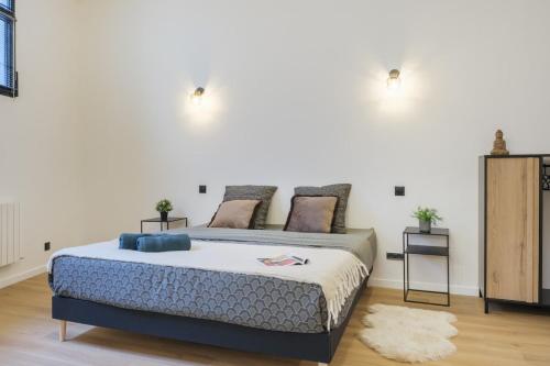 Un dormitorio con una cama grande con dos mesitas de noche. en 110 m2 loft-style apartment, en Burdeos