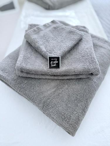 a gray towel sitting on top of a bed at Chic Luxury Apt Gym Balcony 5min to Stadium & Tube in London