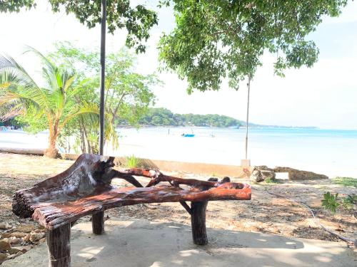 a wooden bench sitting next to a beach at Koh Samed Lung Dam Hutbeach in Ao Phutsa