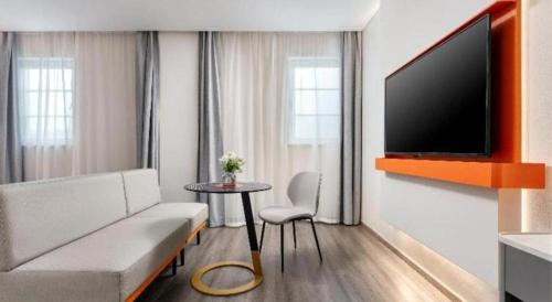 a living room with a couch and a table with a tv at ibis Dongguan Dongcheng in Dongguan