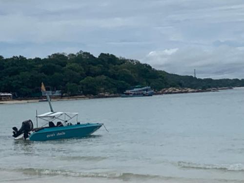 a blue boat sitting in the water on a beach at Koh Samed Lung Dam Hutbeach in Ao Phutsa