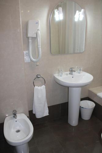 a bathroom with a sink and a toilet and a mirror at Hostal Amantes De Teruel in Teruel