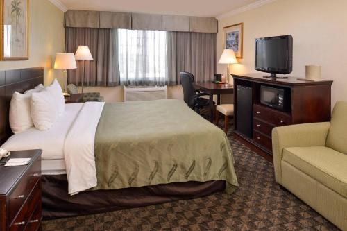 a hotel room with a bed and a flat screen tv at Quality Inn & Suites Montebello - Los Angeles in Montebello