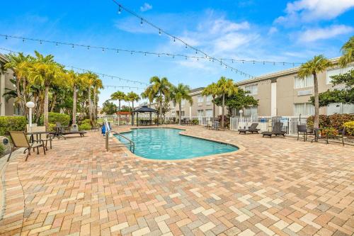 a swimming pool with a playground and palm trees at Quality Inn & Suites Tampa near Fairgrounds and Casino in Tampa