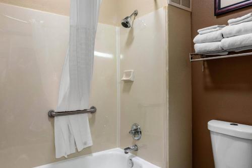 a bathroom with a shower and a toilet and towels at Comfort Suites The Colony - Plano West in The Colony
