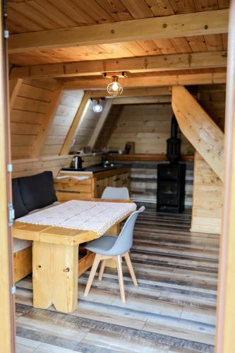 a kitchen with a table and chairs in a cabin at Etno SELO Uskoci in Uskoci
