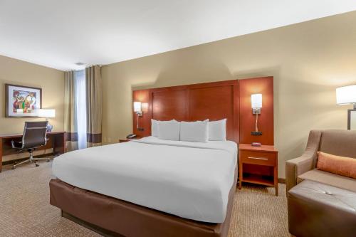a large white bed in a hotel room with a chair at Comfort Inn Memphis Downtown in Memphis