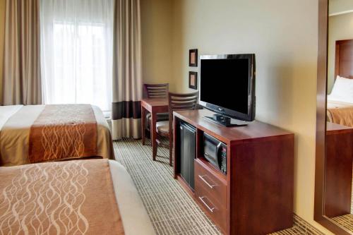 a hotel room with a flat screen tv and a bed at Comfort Inn West Monroe near Sports & Events Center in West Monroe