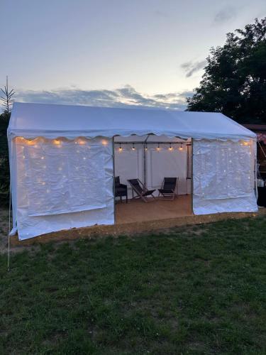 a blue tent with two chairs in a yard at Ranczo Rogowo jacuzzi sauna staw rybny in Rogowo