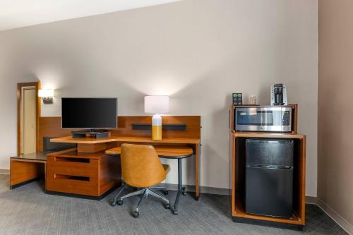 a room with a desk with a computer and a microwave at Comfort Inn & Suites Akron South in Akron