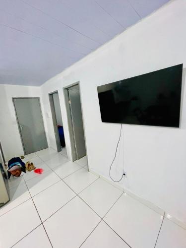 a room with a large flat screen tv on a wall at Apartamento semi mobiliado em Ananindeua in Ananindeua