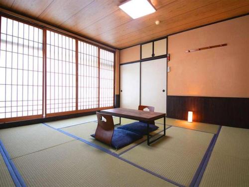 a room with a table in a room with windows at Business Hotel Wako in Ichinomiya
