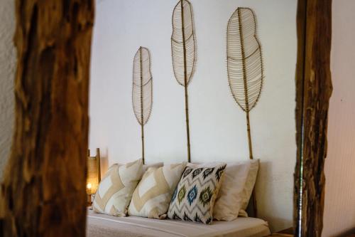 a mirror with three feather sculptures on a couch at Spacious 3bdrs villa walkable to Bingin Beach in Uluwatu