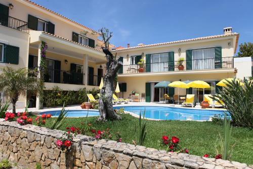 a resort with a swimming pool and a building at Vila De Sol in Sesimbra