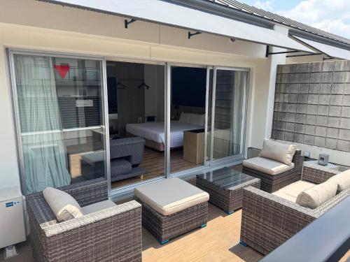 a balcony with wicker furniture and a bedroom at Sakura Terrace The Gallery in Kyoto