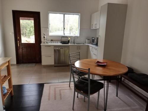 a small kitchen with a wooden table and chairs at Kent River Retreat in Kentdale