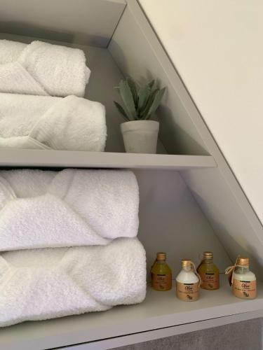 a pile of towels on a shelf with a plant at TriPeak in Bjelašnica