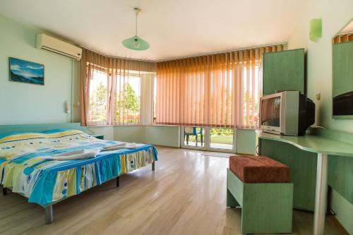 a bedroom with a bed and a tv in it at Guest House ,, Ekaterina" in Nesebar