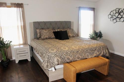 een slaapkamer met een bed met een dekbed en een bankje bij Luxurious 5-Bedroom Retreat with Saltwater Pool and Spa in Elk Grove