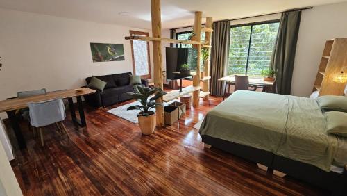 a bedroom with a bed and a desk and a living room at Casa Alba in Cali