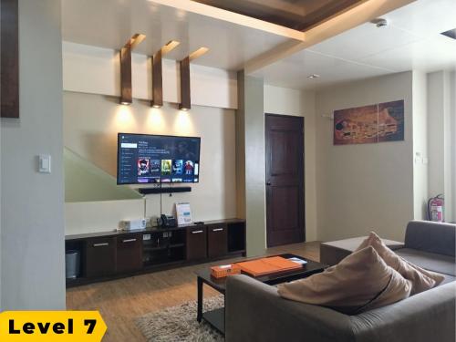 a living room with a couch and a flat screen tv at Lalaguna Villas Luxury Dive Resort and Spa in Puerto Galera