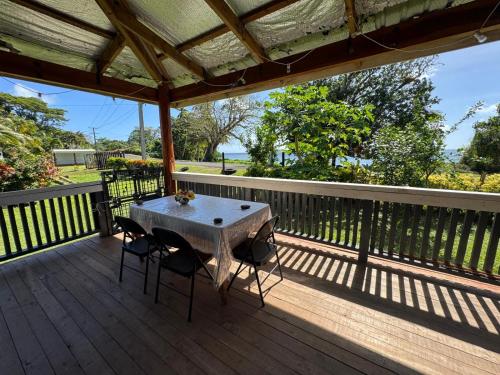 a table on a deck with two chairs on it at Lisi's ocean Breeze Escape 