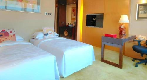 a bedroom with two beds and a desk and a desk at Radegast Hotel CBD in Beijing