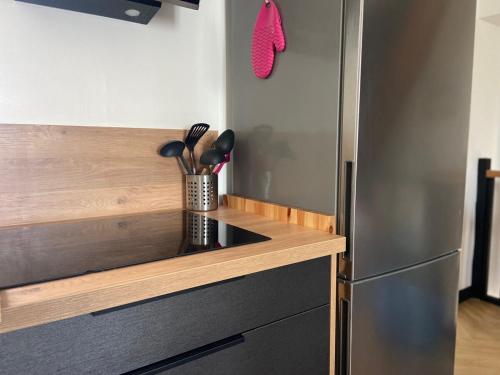 a kitchen with a stainless steel refrigerator and a counter at Chez Julien - Maison 5 personnes in Trouy