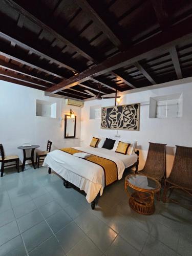 a bedroom with a large bed and a table and chairs at Vrindavanam Heritage Home in Alleppey