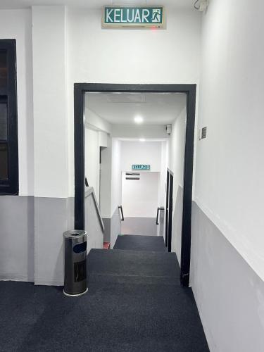 a hallway in an office building with a sign on the wall at Quee Hotel in George Town
