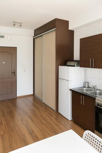 a kitchen with white and brown cabinets and wooden floors at Noclegi Międzylesie - Aktywny Wypoczynek in Międzylesie