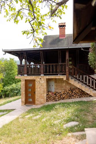 a building with a pile of fire wood in front of it at Forest Heaven Retreat with jakuzz in Čačak