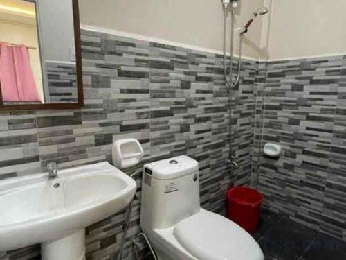 a bathroom with a toilet and a sink at Pilot Hotel in Alaminos