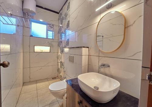 a white bathroom with a sink and a toilet at King Palace Ooty by VOYE HOMES in Ooty