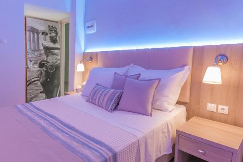 a bedroom with a bed with purple and white pillows at 12 Olympian Gods in Platamonas
