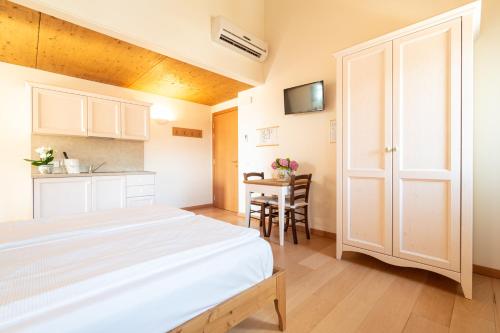 a bedroom with a bed and a table and a kitchen at Agriturismo Il Follo in Valdobbiadene