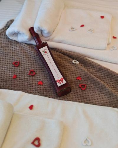 a thermometer laying on a bed with hearts on it at POOL RESORT Vila Lena - Lux residence apartman 1 in Vrdnik