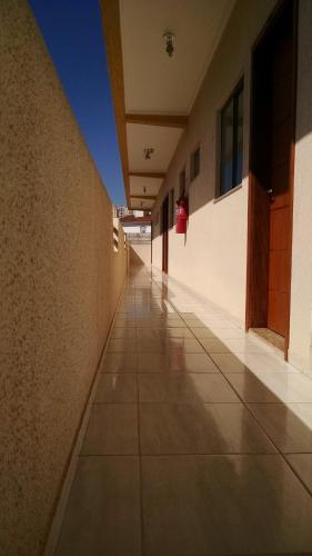 an empty hallway of a building with a tile floor at Áries Apart Hotel in Bauru