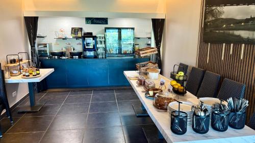 a restaurant with a counter with a table with food at Logis Hôtel Restaurant Bellevue in Saint-Martin-dʼArdèche