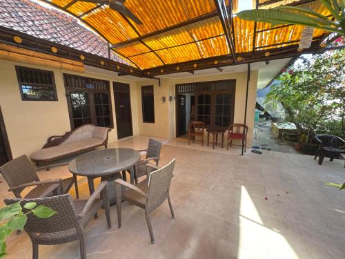 an outdoor patio with a table and chairs at Chez Suaidah Djamade - Private rooms in private home in Kuta in Ngurah Rai International Airport