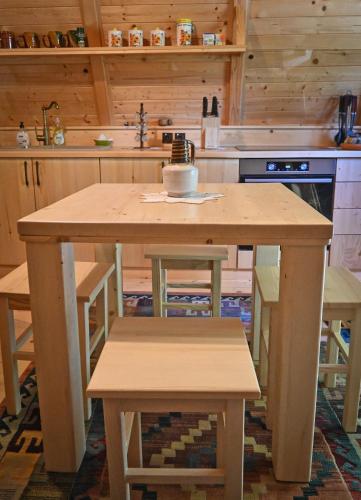a kitchen with a wooden table and some chairs at Glamping and wellness cottage Salvus in Lendava