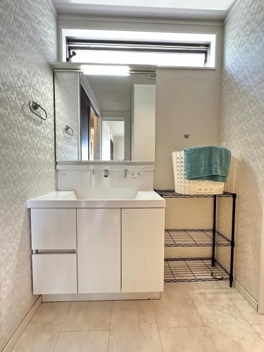 a bathroom with a white sink and a mirror at リゾートヴィラ宮島 Sunset terrace in Hatsukaichi